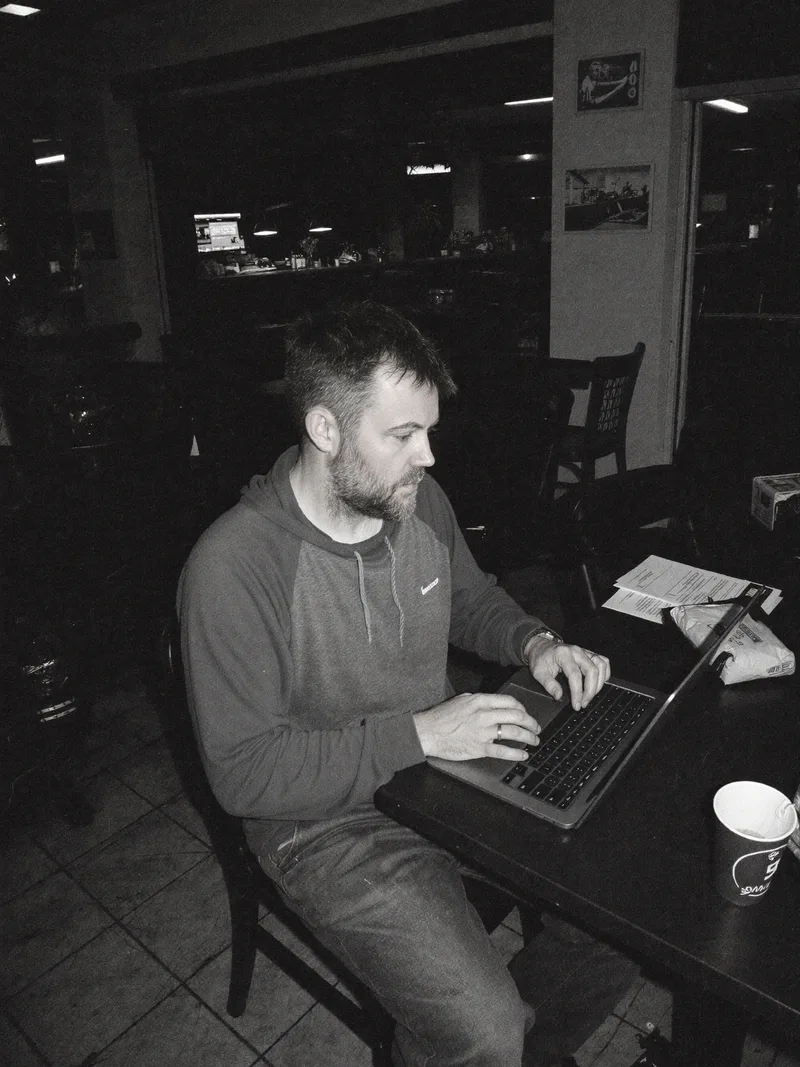 Darren Walker working on a laptop at a cafe table