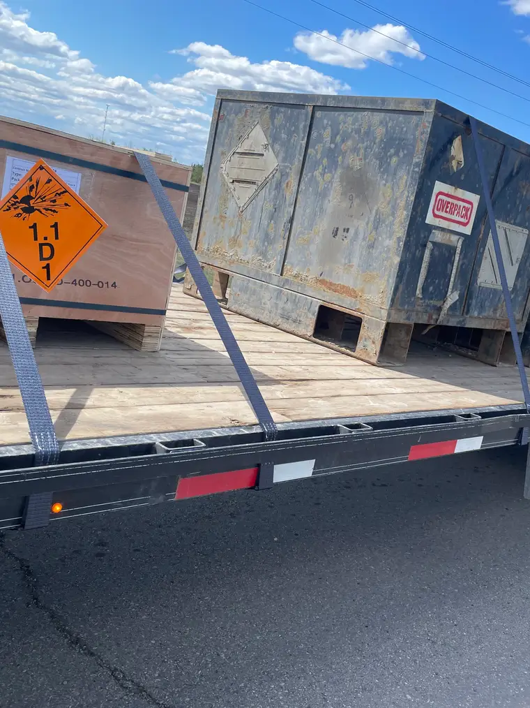 Wellsite shacks strapped down on a Nash Services deck trailer