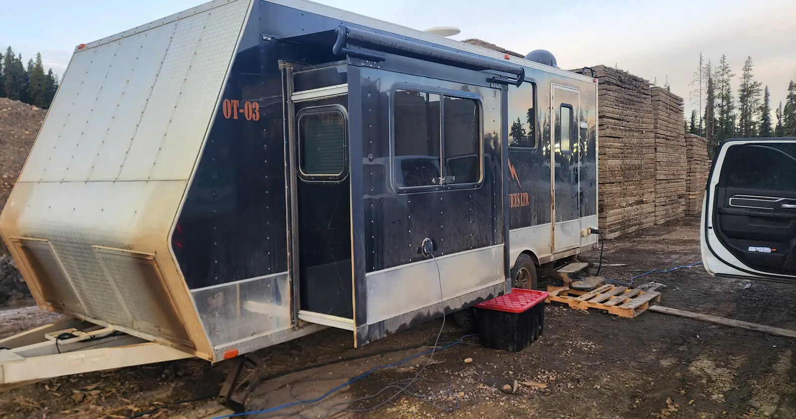 A Nash Services office trailer and rig mat stacks at golden hour