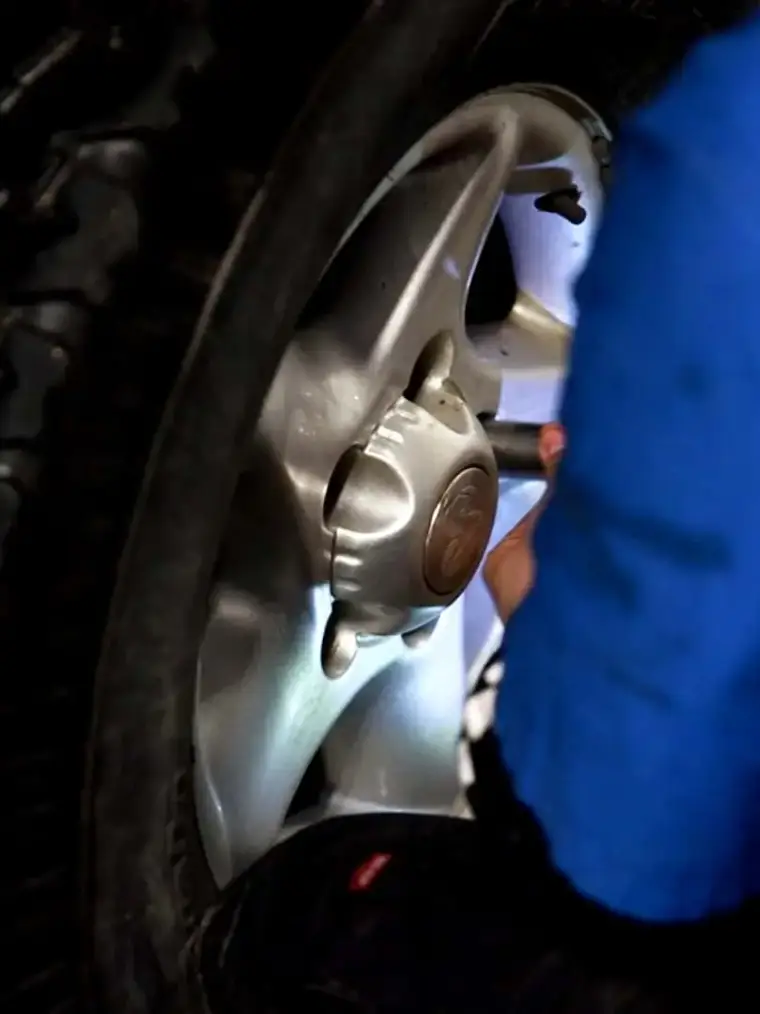 A Quick Lane technician working on a wheel during an alignment